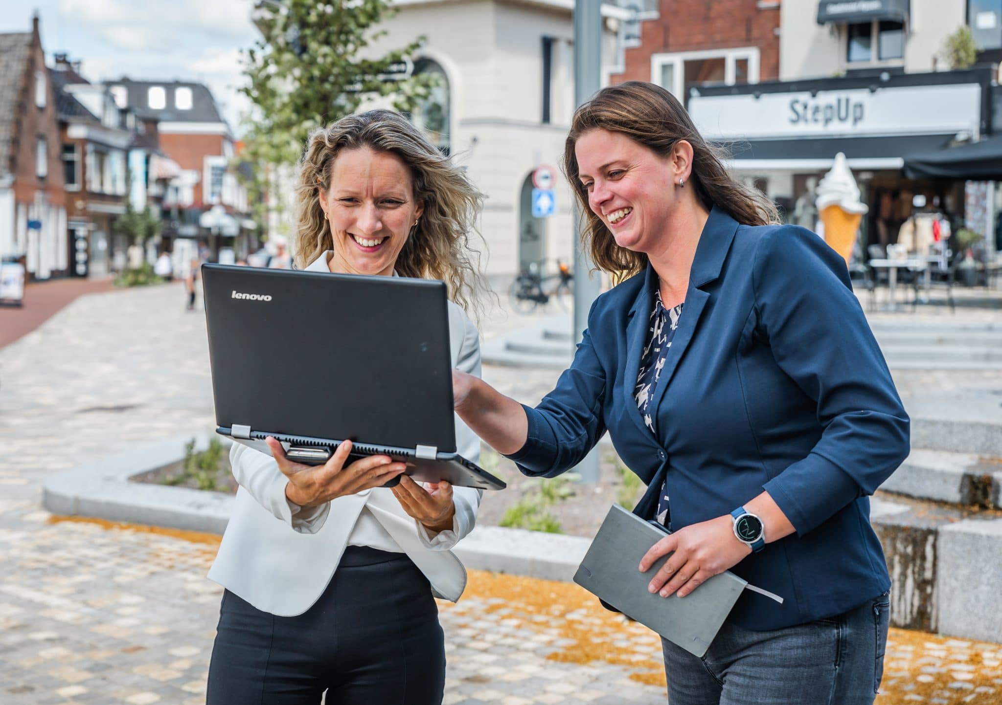 Accountmanagers Vera Haken (links) met laptop en Annemiek Mensink (rechts) in het centrum van Rijssen.