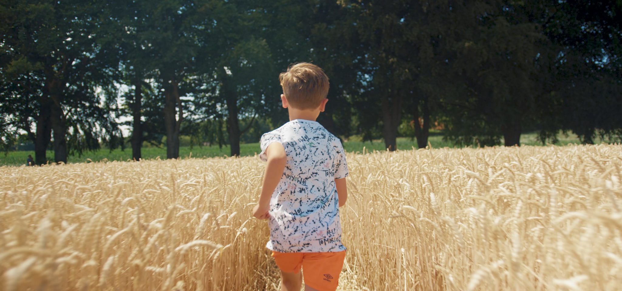 Kind rent door graanveld in het buitengebied