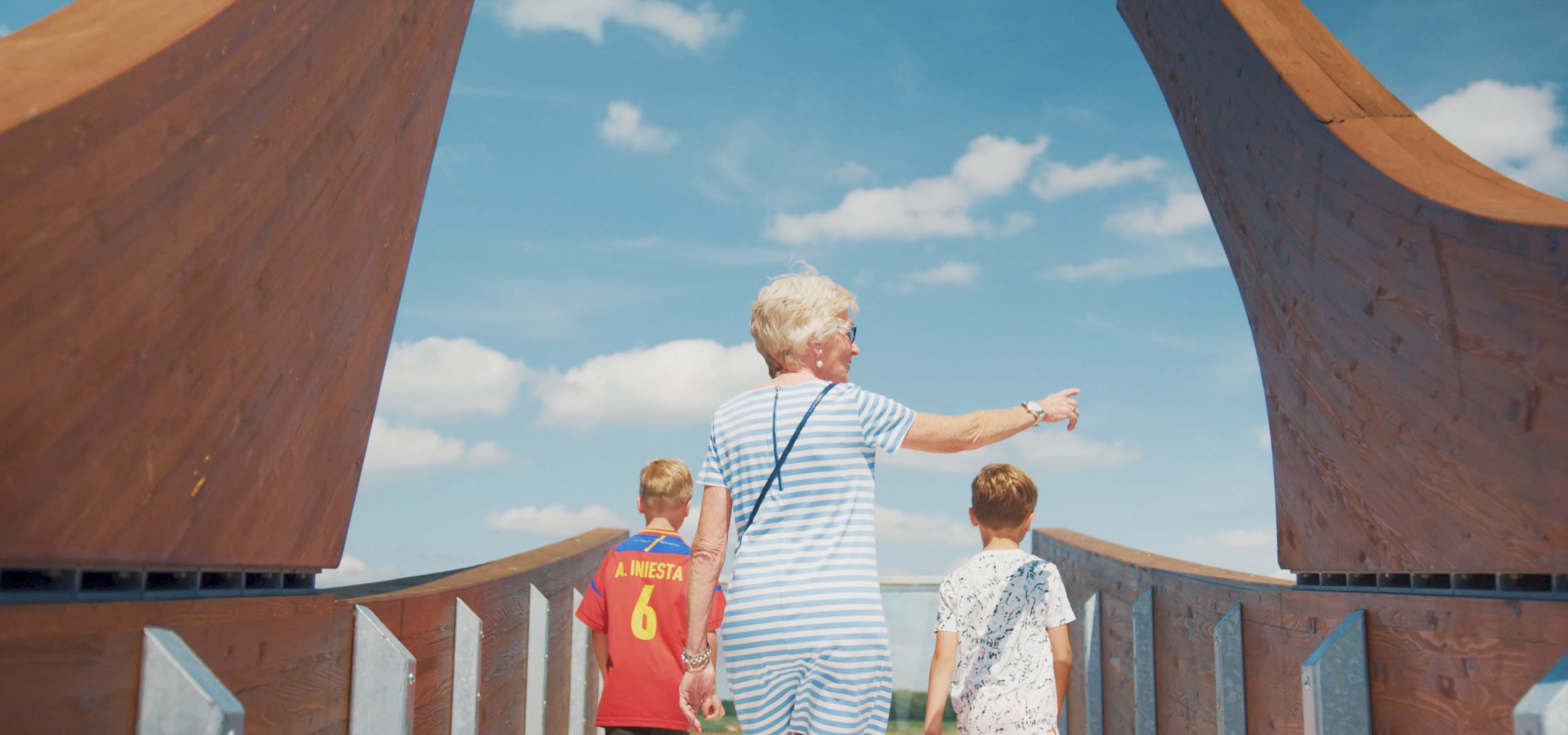 Een oma en 2 kleinkinderen staan op het uitkijkpunt onderaan de Holterberg