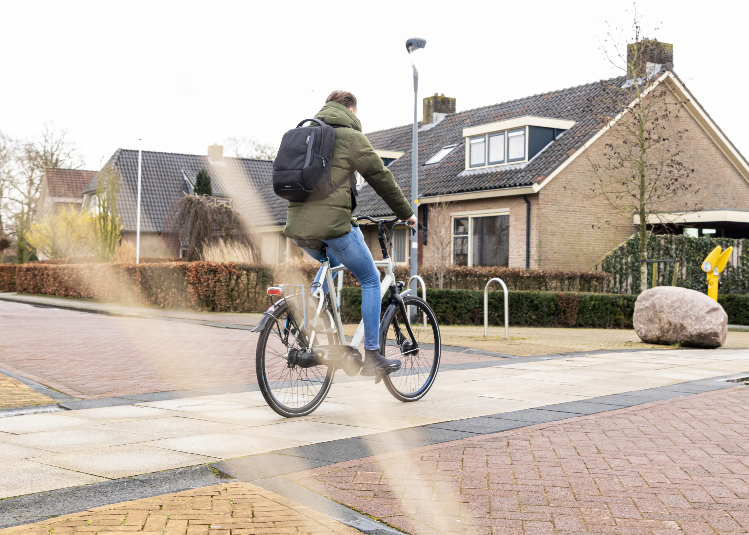 Een fietser rijdt in een woonwijk