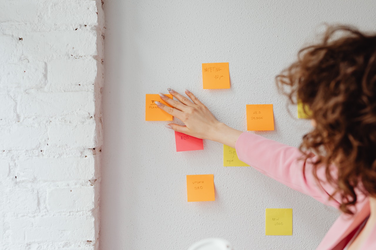 Vrouw plakt memoblaadjes op een muur